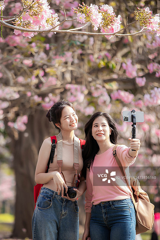 两名亚洲女游客花园散步并自拍图片素材