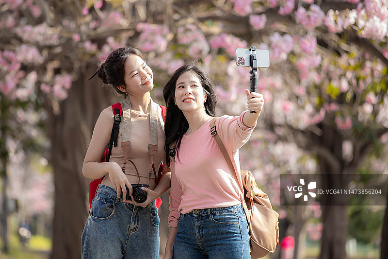 两名亚洲女游客花园散步并自拍图片素材