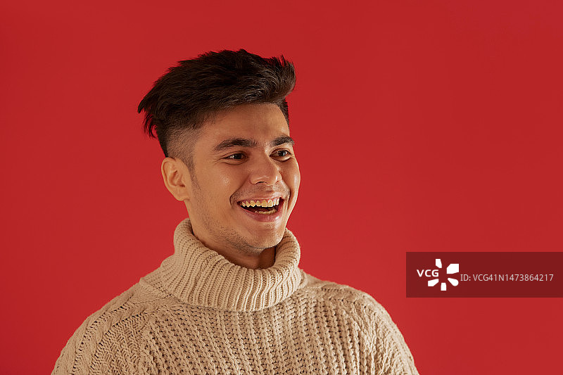 身穿冬季毛衣面带微笑看向远方的年轻男子肖像图片素材