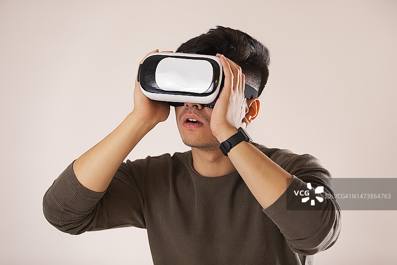 一位兴奋的年轻男子体验虚拟现实眼镜的肖像图片素材