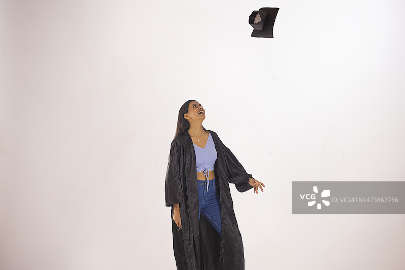 年轻女子将毕业帽扔向空中图片素材