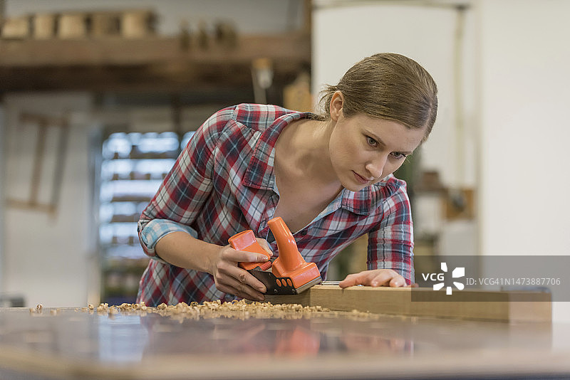 在车间刨木头的专注实习生图片素材