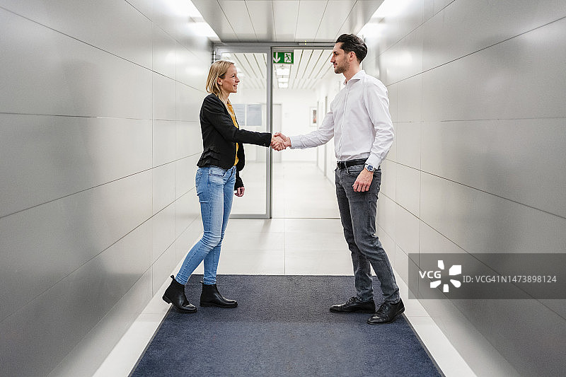 商务同事在走廊握手图片素材