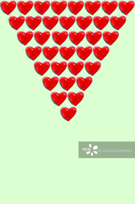 绿色背景上的成排心形糖果图片素材
