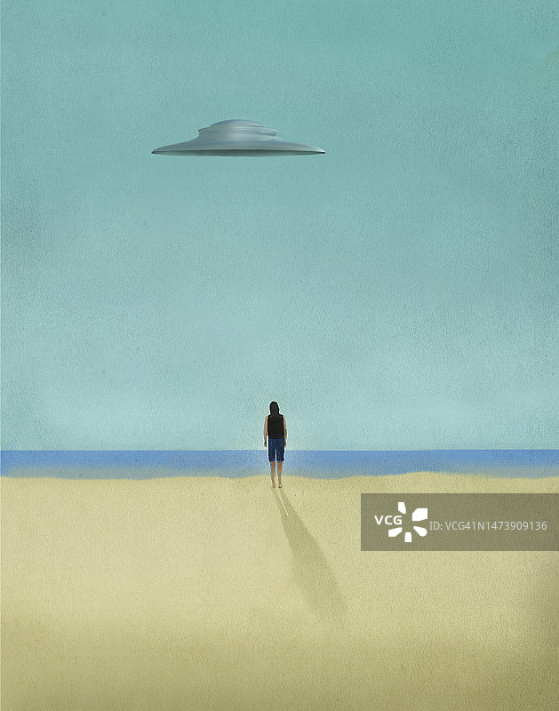 看着沙滩上飞碟的人图片素材