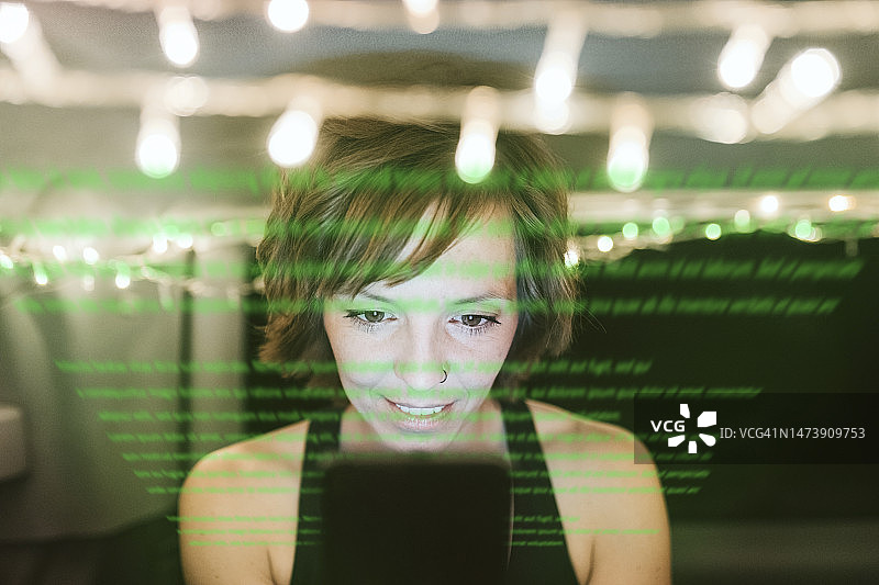 晚上用智能手机发短信的微笑女人图片素材