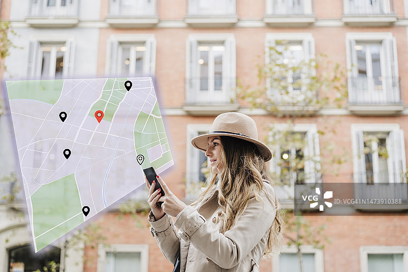 女子在建筑物前使用智能手机导航图片素材