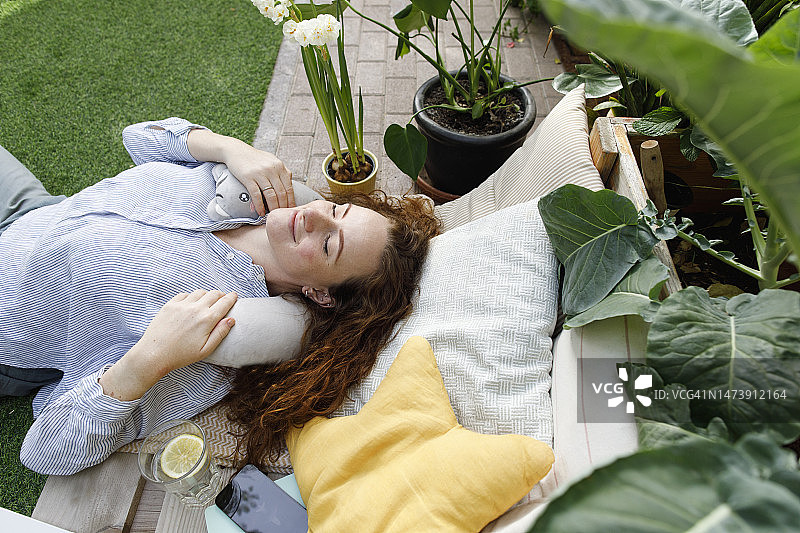 在后院躺在颈枕上的女人图片素材