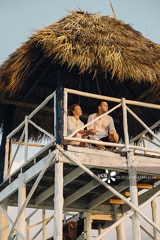 情侣坐在高脚屋里度过休闲时光图片素材