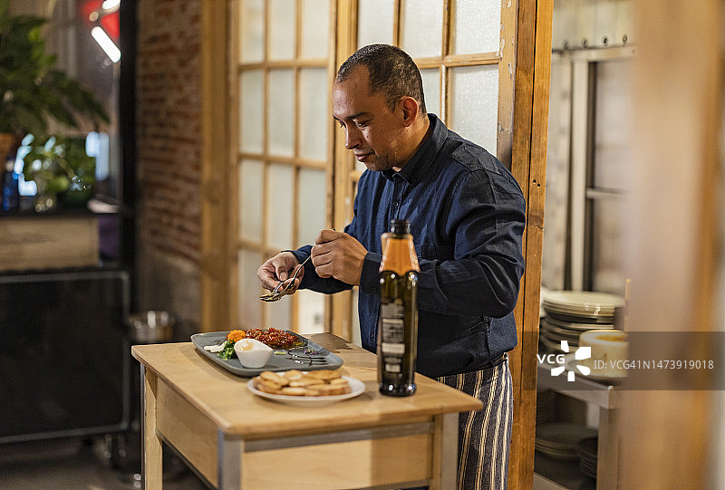 厨师在餐厅对菜肴进行最后的润色图片素材