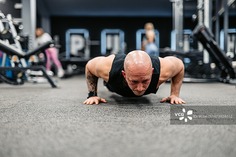 在健身房做俯卧撑的年轻人图片素材