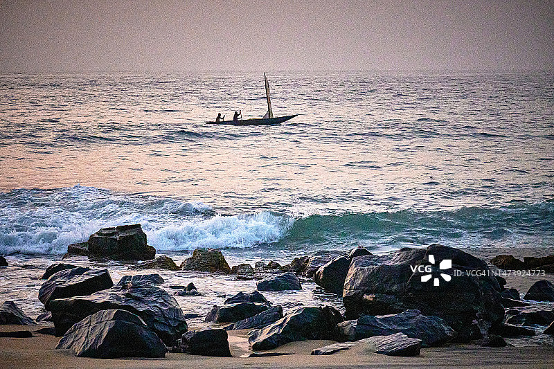 远处一艘收起船帆的小渔船图片素材