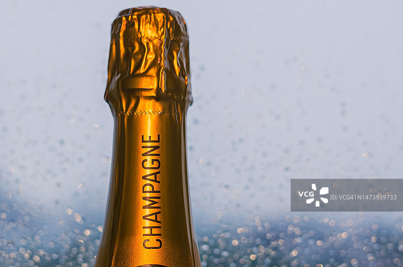 闪亮的香槟酒瓶顶部，窗户背景有雨滴图片素材