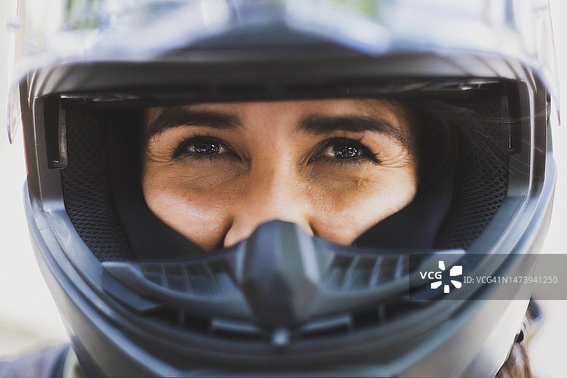 从摩托车头盔深处看向镜头的拉丁裔女人 - 墨西哥，墨西哥城，特写图片素材