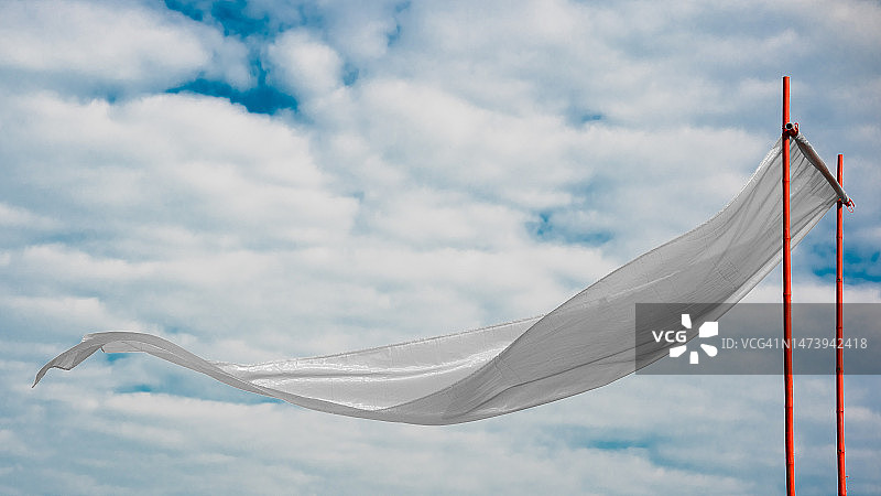 白色丝绸在白色云朵的背景下展开图片素材