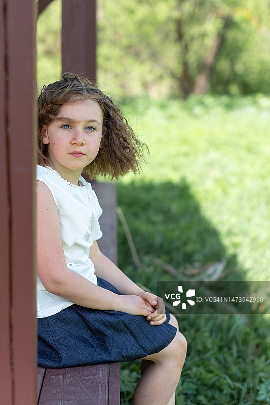 穿着白色衬衫的女孩放学后在公园里散步，俄罗斯图片素材
