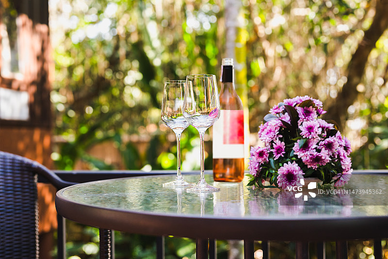 户外桌子上的玫瑰红葡萄酒瓶和酒杯，泰国图片素材