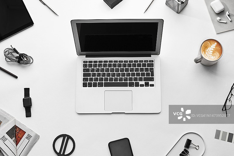俯瞰白色背景上的笔记本电脑、咖啡和办公用品图片素材