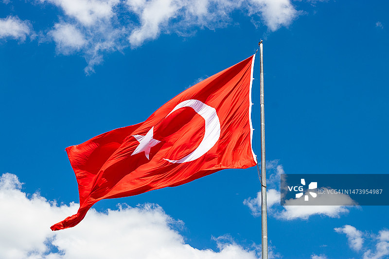 土耳其国旗在天空背景中飘扬，旗帜上有星月标志图片素材