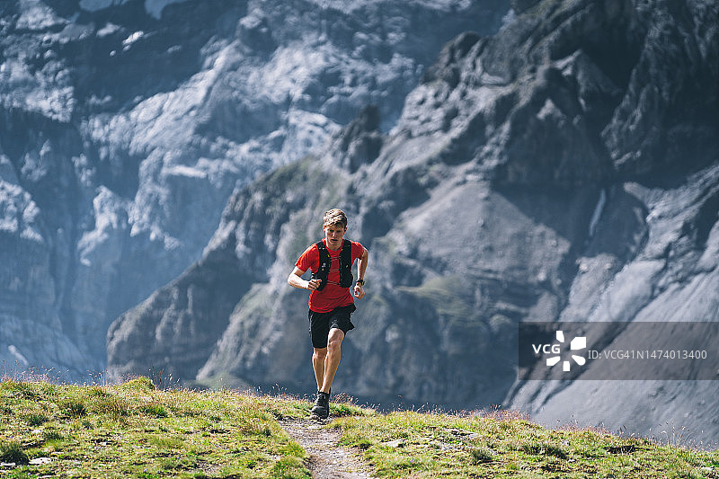 越野跑者穿过高山草甸，攀登山路图片素材