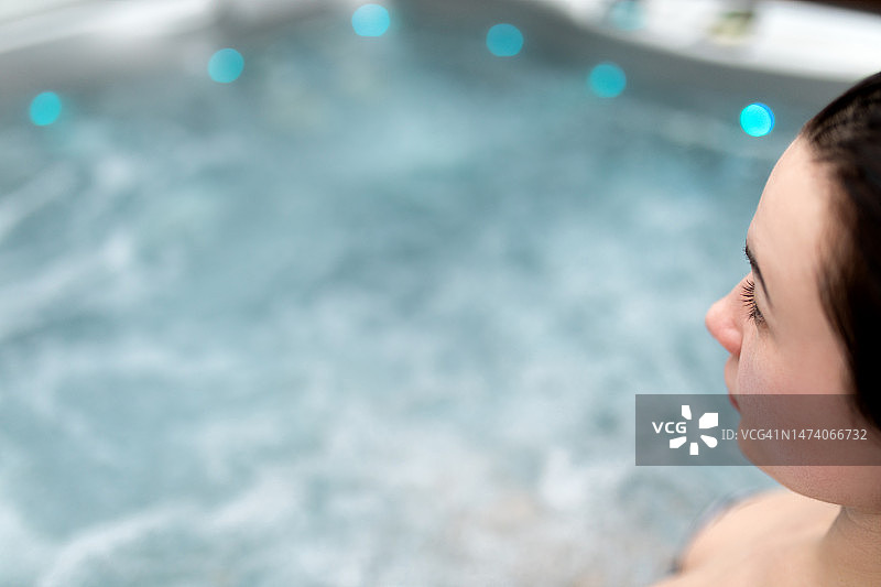 在有流动水的热水浴缸里的女人图片素材