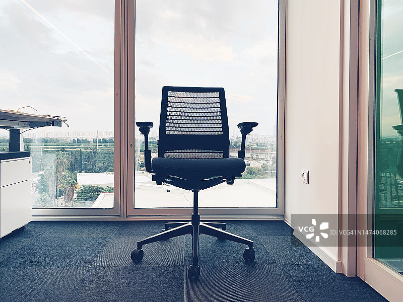 办公室内的办公椅，背景是大型全景窗图片素材
