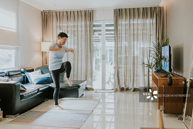 健康生活方式：退休人员在家进行有氧运动图片素材