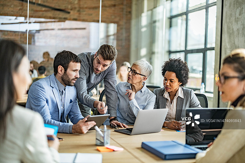 商务团队在办公室会议中使用无线技术图片素材