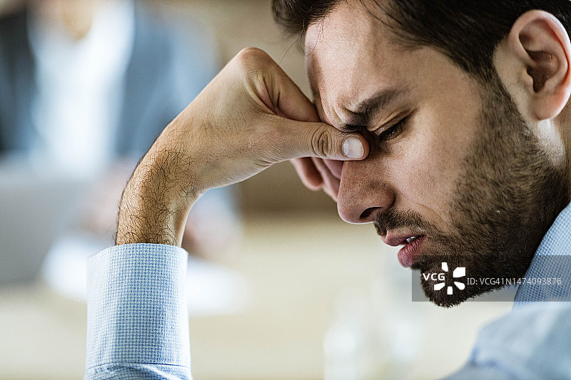 不悦的商人头痛在办公室图片素材