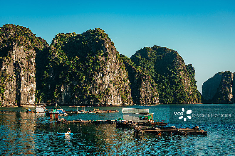 越南下龙湾的漂浮渔村和岩石岛屿图片素材