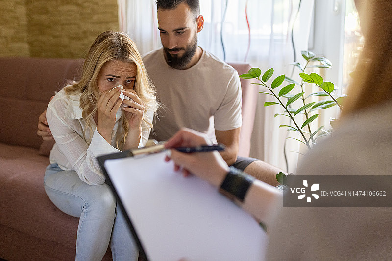 精神科医生在诊疗期间记录，妻子在丈夫面前哭泣图片素材
