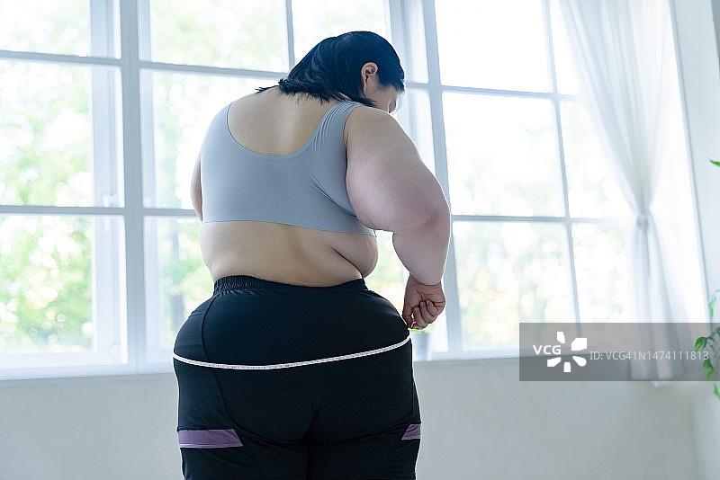 女子用卷尺测量臀围尺寸图片素材