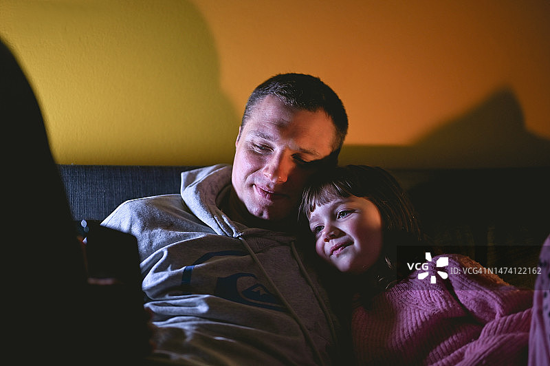 全家在沙发上用智能手机放松身心图片素材