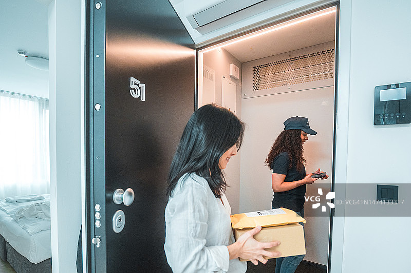 年轻的亚洲女性在家接收快递包裹图片素材
