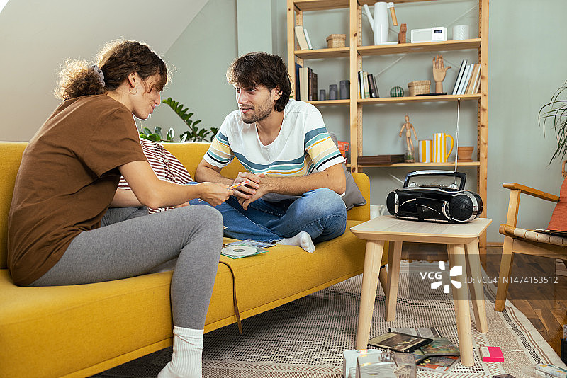 年轻情侣享受CD带来的复古音乐图片素材