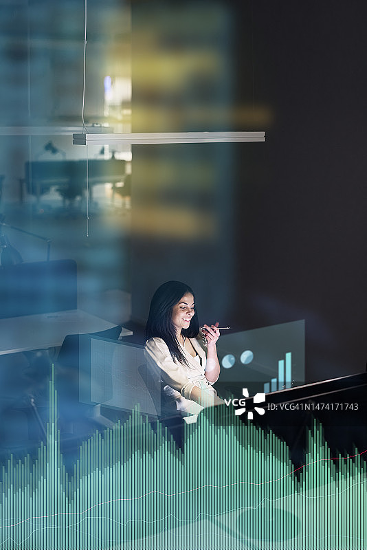 在晚上在办公室工作的年轻女商人图片素材