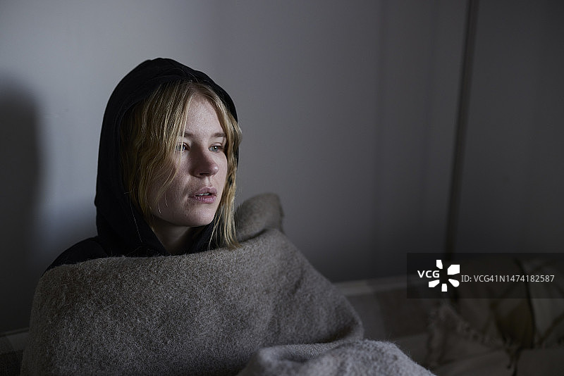 裹着毯子坐在沙发上的少女图片素材