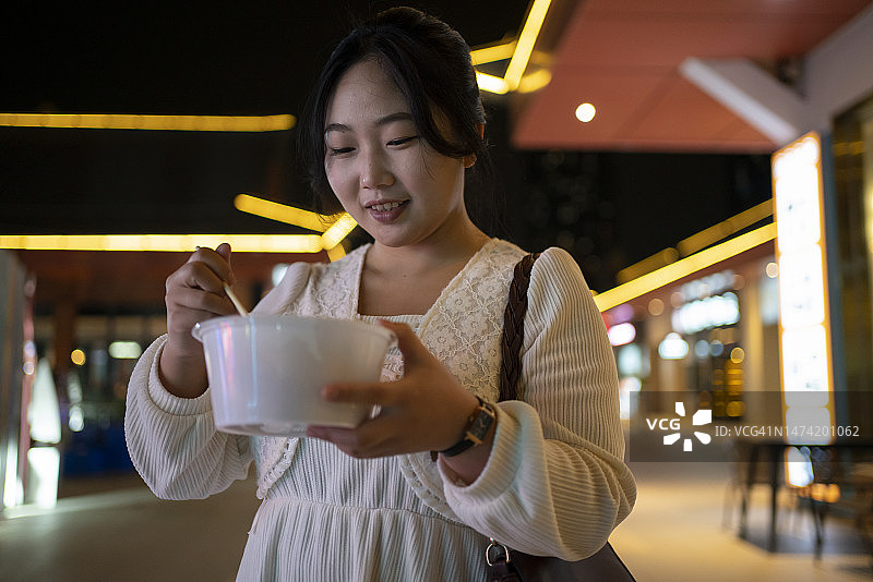 亚洲女性在旅途中愉快地享用美食图片素材