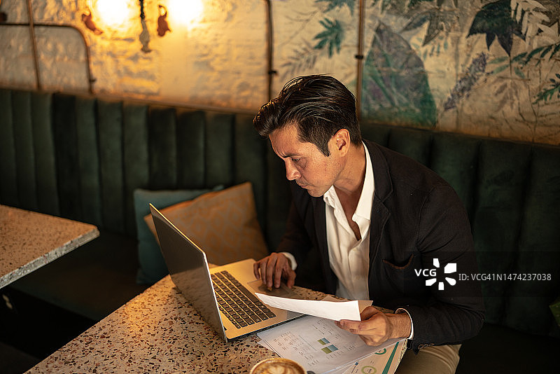 中年商人咖啡馆用笔记本电脑进行财务分析图片素材