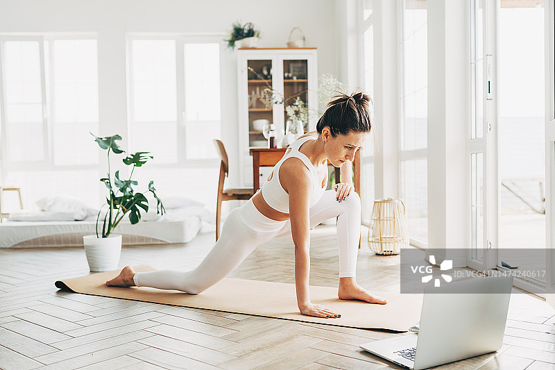 健身女性在客厅平板支撑在线学习图片素材