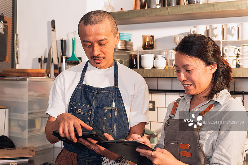 咖啡师通过平板电脑检查库存图片素材