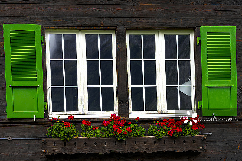 带有彩绘百叶窗和花盆的高山小屋图片素材