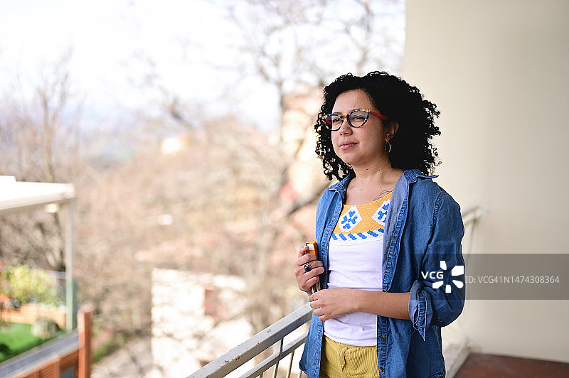 在阳台上享受好天气的一位多种族女性图片素材