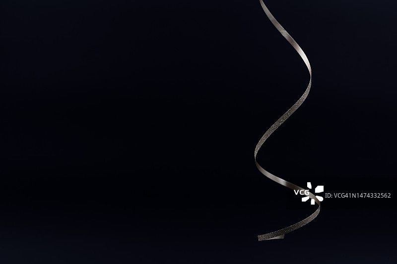 黑色背景上闪闪发光的银色金属亮片丝带图片素材