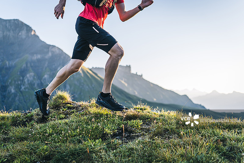 越野跑者穿过高山草甸，攀登山路图片素材