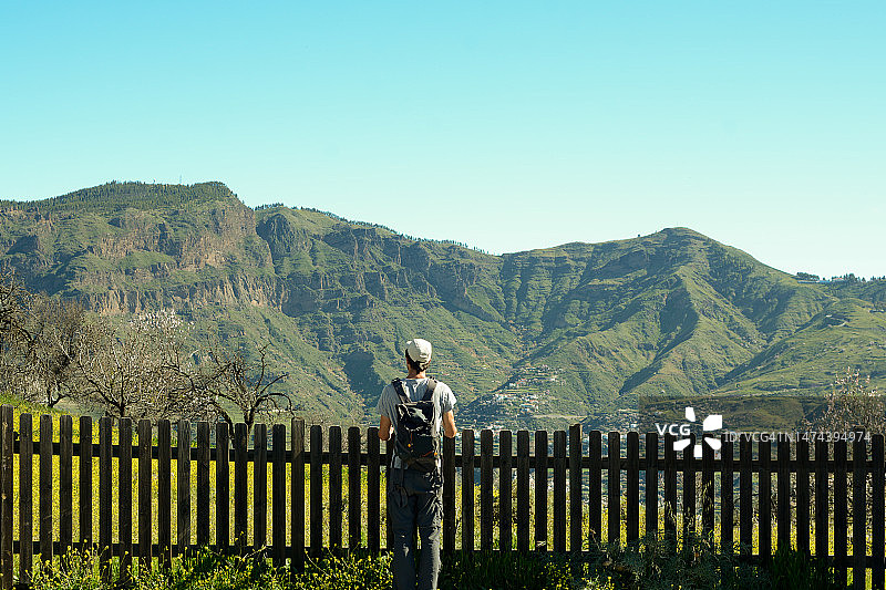 男子倚靠在栅栏上欣赏风景图片素材
