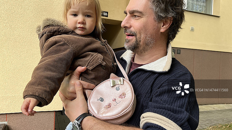 中年男人抱着他的幼儿女儿，充满爱意地看着她图片素材