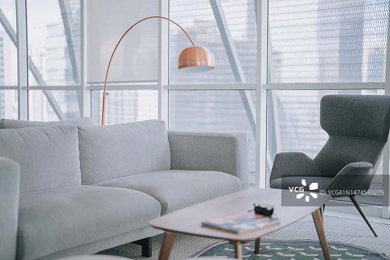 办公室休息区：沙发、扶手椅和咖啡桌，窗外是城市建筑图片素材