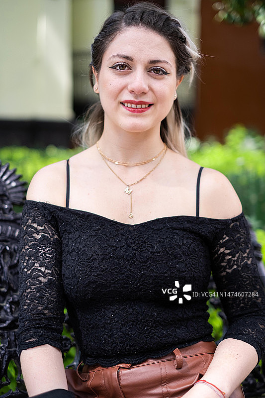 年轻的拉丁裔女人在墨西哥城微笑地看着镜头，深棕色和铂金色头发，中景图片素材