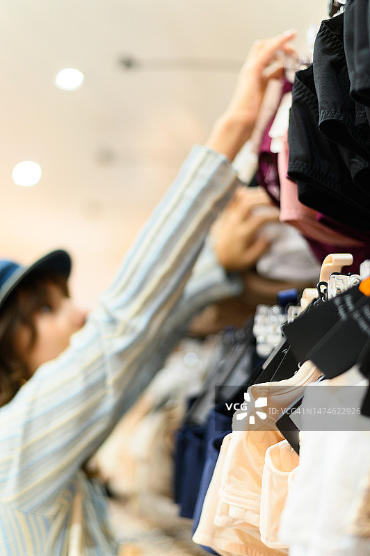 在商店里购买内衣的女人竖版照片图片素材